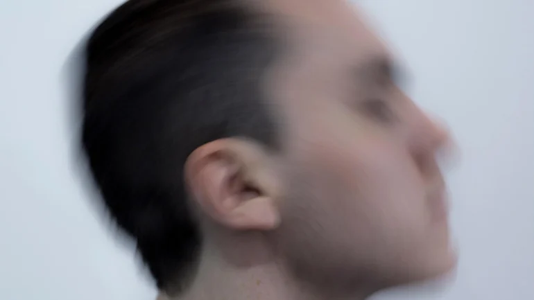 Blurred image of Patrick against a white backdrop.