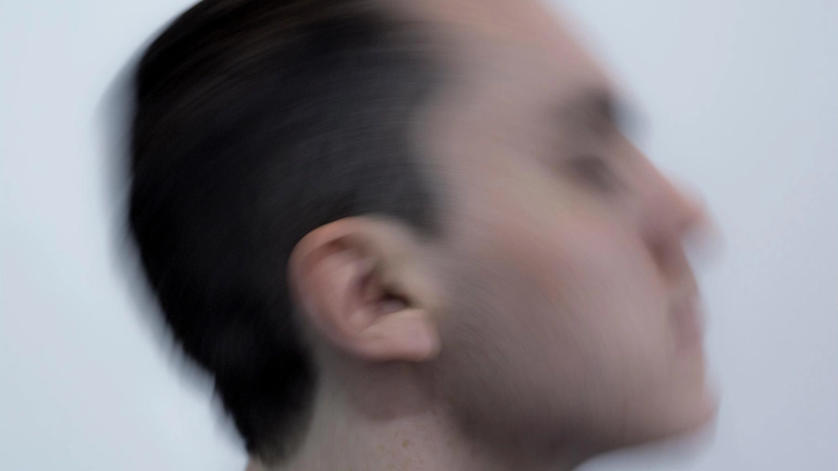 Blurred image of Patrick against a white backdrop.