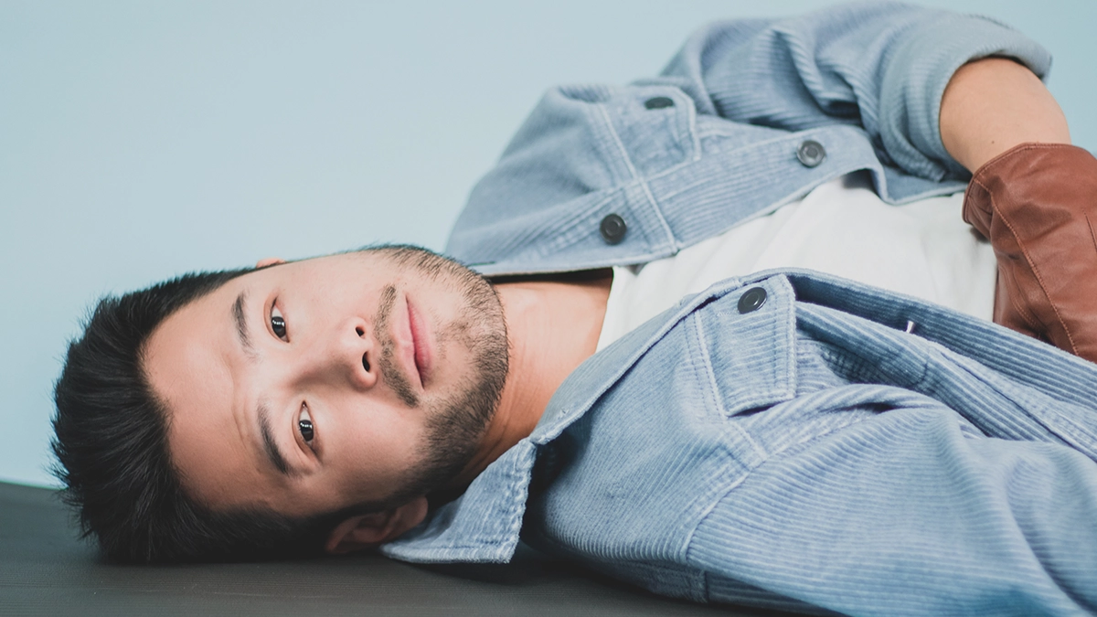 Wills was unshaven, wearing jeans, a jacket, a white t-shirt, and brown leather gloves.