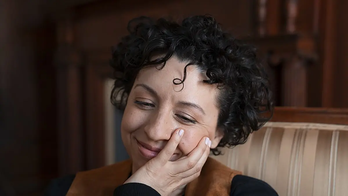 Emily Nicole Green sitting down smiling with closed eyes.