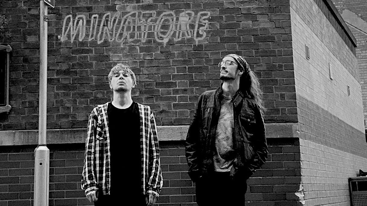 Minatore standing in front of a brickwall.