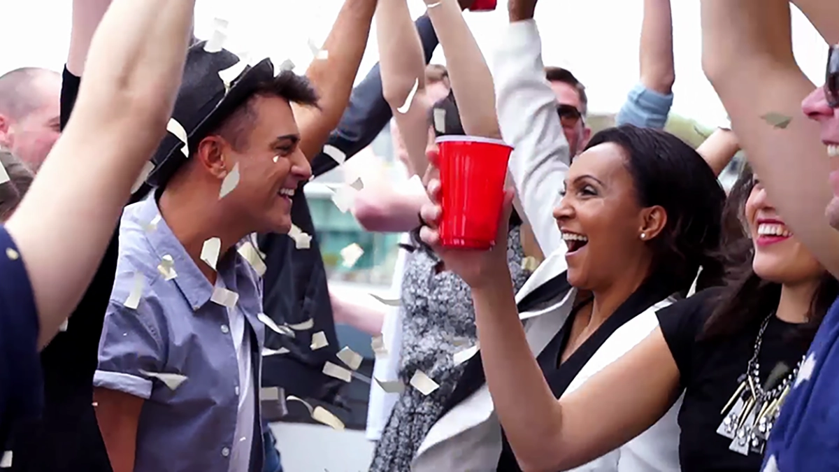 Rozalla and Allan Jay dancing and cheering, surrounded by party people. Confetti in the air.